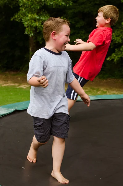 Child playing while jumping on trampoline outdoors on spring day — Stock Photo, Image