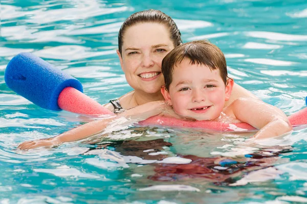 Mamma att ge sonen en simning lektion i poolen under sommaren — Stockfoto