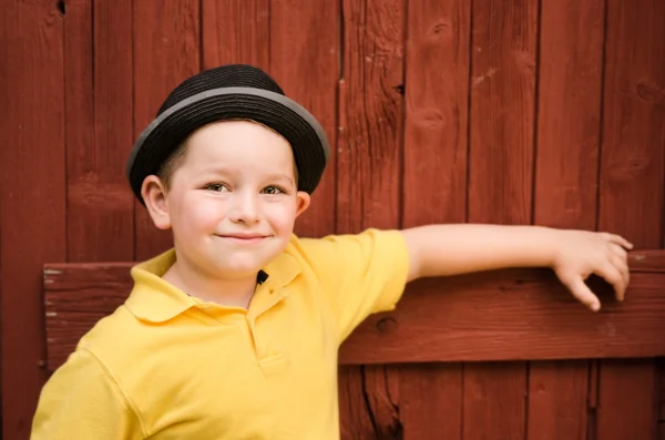 Portret van kind het dragen van fedora hoed naast rustieke schuur — Stockfoto