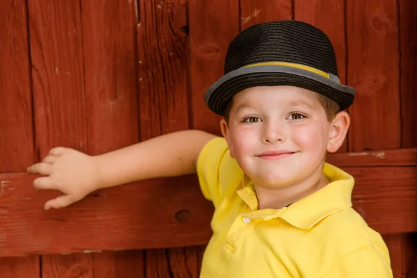 Retrato de criança usando chapéu fedora ao lado do celeiro rústico — Fotografia de Stock