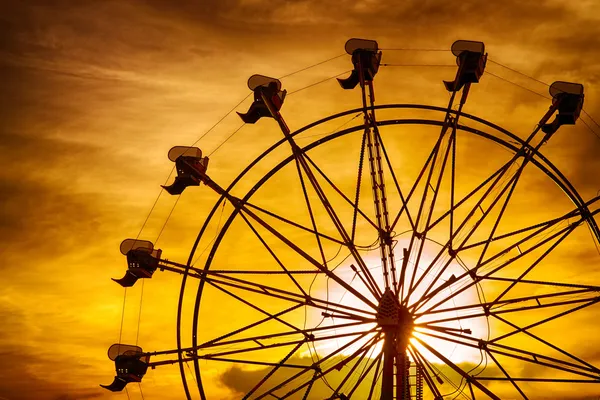 Silhueta de roda gigante ao pôr do sol durante o verão na feira do condado — Fotografia de Stock