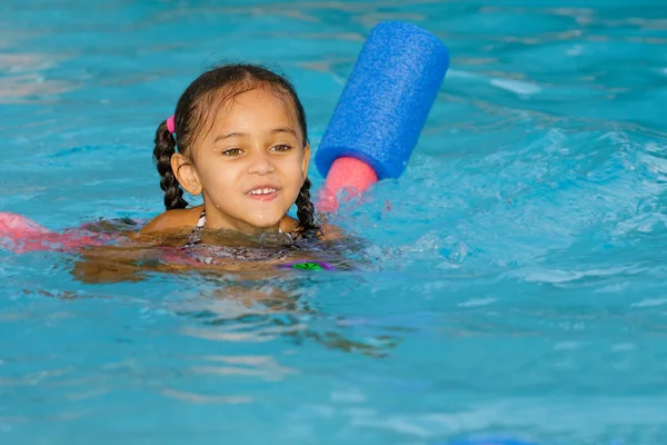 Bastante mixta niño nadando en la piscina durante el verano — Foto de Stock