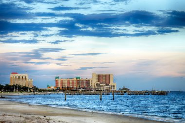 Biloxi, Mississippi, casinos and buildings along Gulf Coast shore at sunset clipart
