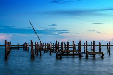 Broken pier and mast of broken ship in water after sunset in Biloxi, Mississippi clipart