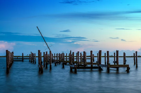 Trasiga pier och mast trasiga fartyg i vatten efter solnedgången i biloxi, mississippi — Stockfoto