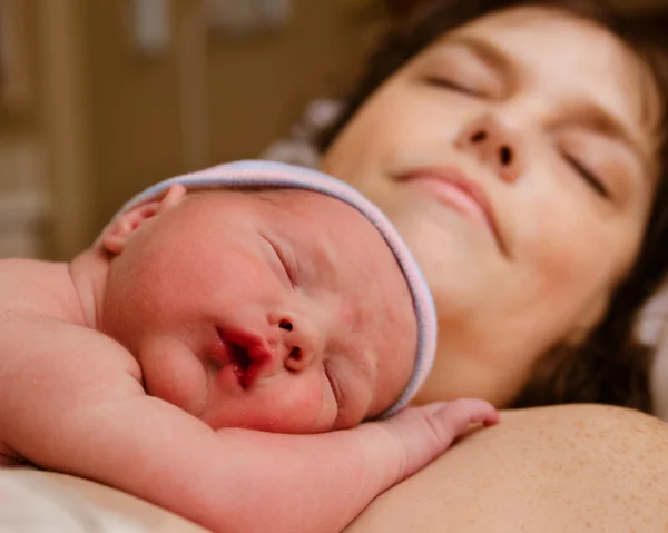 Mother and infant child resting after delivery at hospital Stock Image