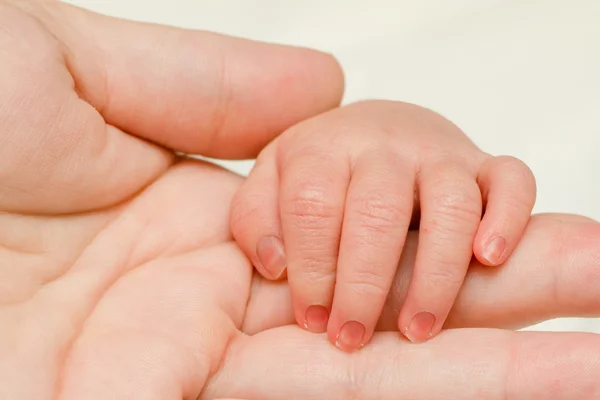 Close up of infant hand on top of mother's hand — Stock Photo, Image