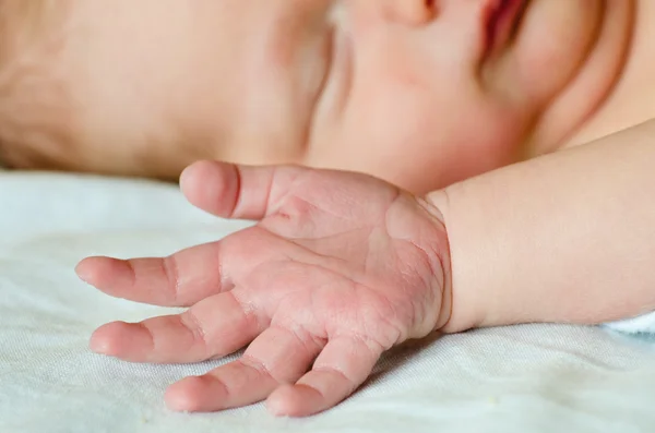 Nahaufnahme der Hand des Säuglings auf dem Bett, während das Kind schläft — Stockfoto