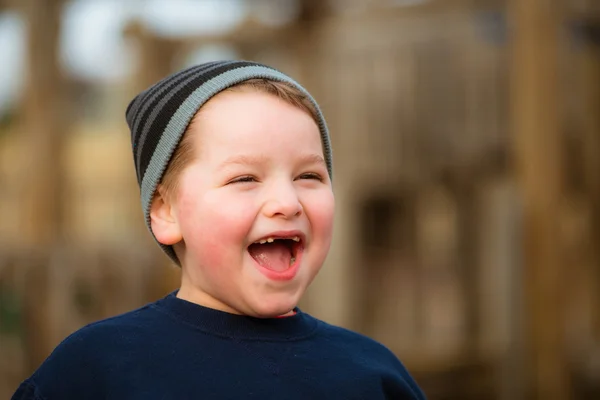 Ritratto invernale di ragazzo felice che gioca nel parco giochi — Foto Stock