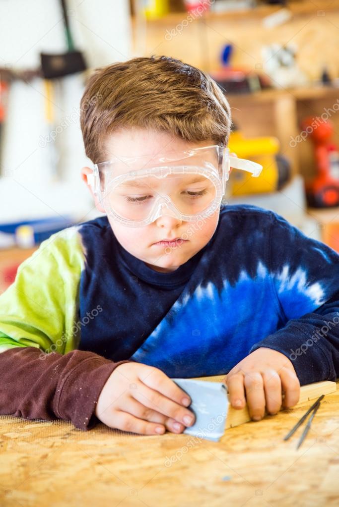 Parent draws stencil on wood block to be used as body for Pinewood Derby car