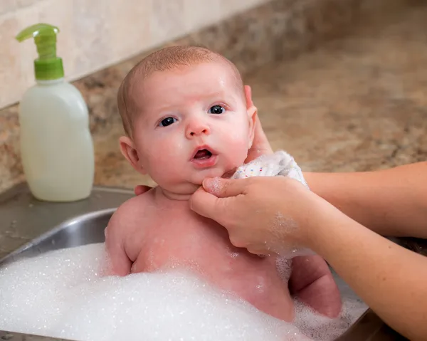 Bathing infant baby boy in sink — Stock Photo, Image