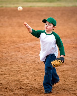 Çocuk beyzbol antrenman sırasında atar.
