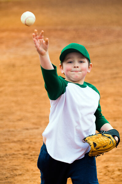 Мальчик бросает бейсбол во время тренировки

