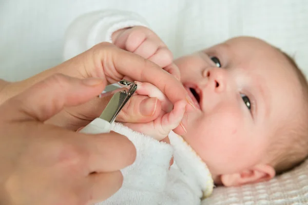 Mère coupant les ongles du bébé avec des coupe-ongles — Photo