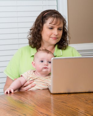 Onu bilgisayarda çalışırken Holding bebek anne