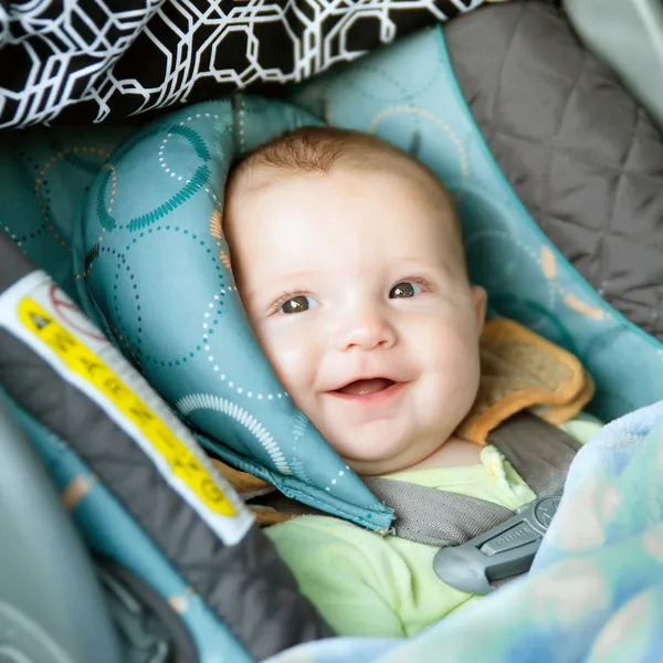 Happy baby buckled into rear-facing car seat — Stock Photo, Image