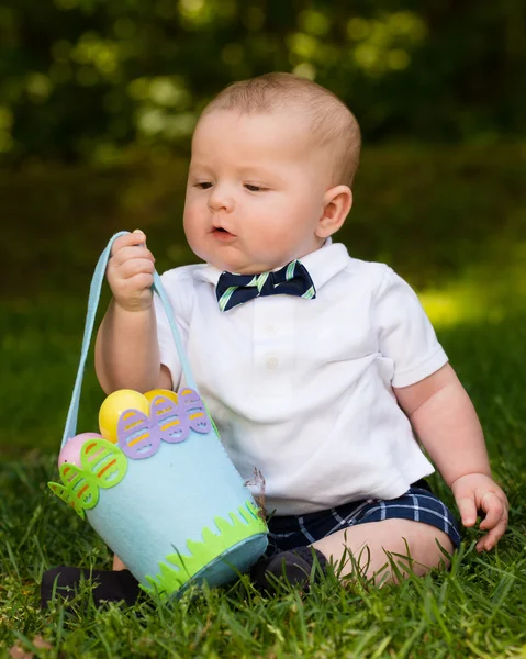 Lindo bebé niño jugando con huevos de Pascua y cesta — Foto de Stock