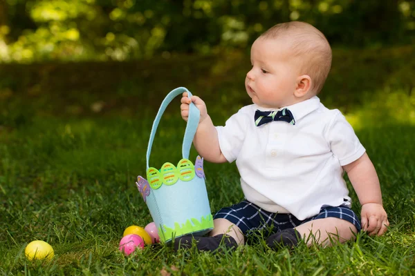 Lindo bebé niño jugando con huevos de Pascua y cesta —  Fotos de Stock