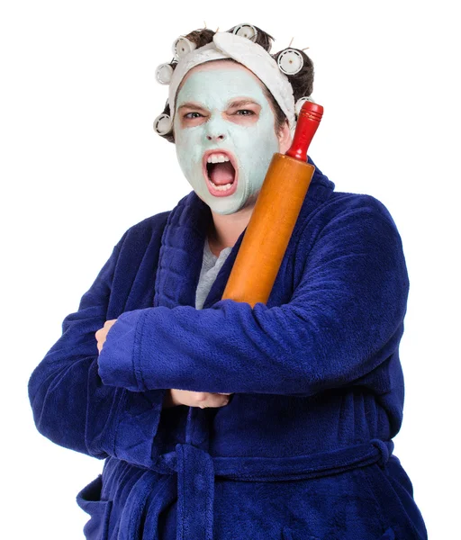 Mean and ugly housewife with facial mask, hair rollers and rolling pin isolated on white — Stock Photo, Image
