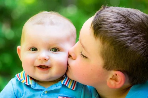 Lycklig pojke kysst av sin äldre bror — Stockfoto