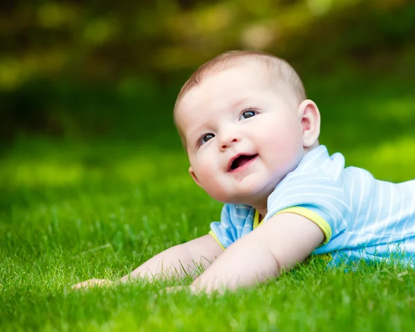 Lente portret van gelukkig babyjongen buiten op gras in veld — Stockfoto