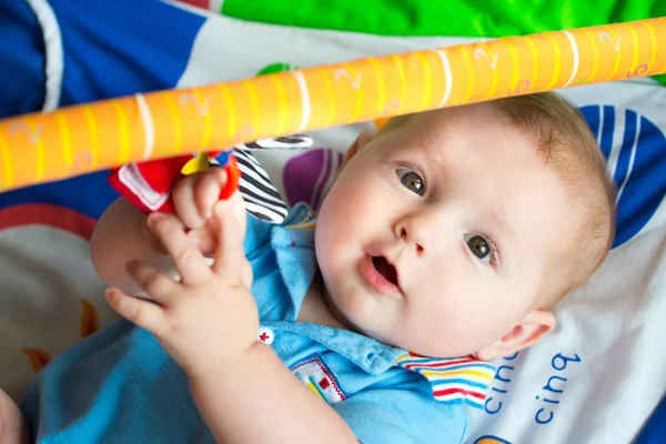 Happy and curious infant baby boy playing on activity mat — Stock Photo, Image