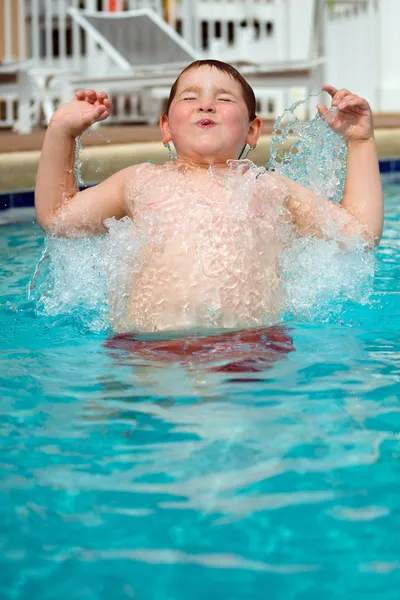 수영 하는 동안 수영장으로 튀는 어린 소년 스톡 사진