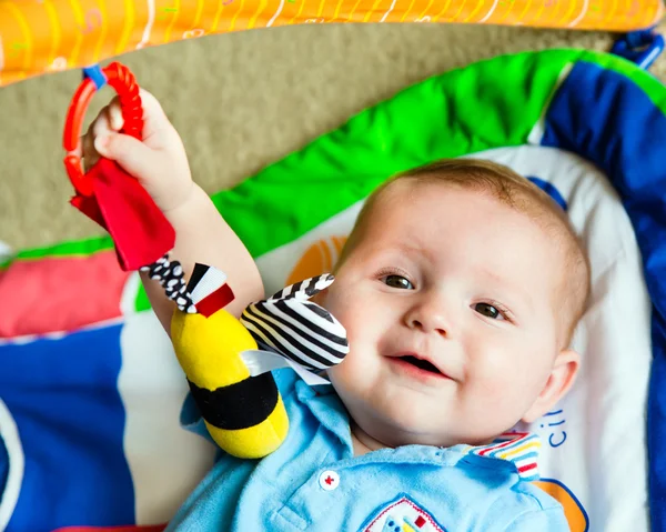 Menino bebê bebê feliz e curioso jogando no tapete de atividade Fotos De Bancos De Imagens
