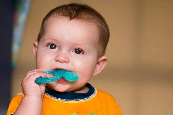 Bebê mastigar no brinquedo anel de dentição — Fotografia de Stock