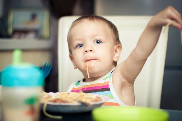 Funny baby boy eating spaghetti — Stock Photo, Image