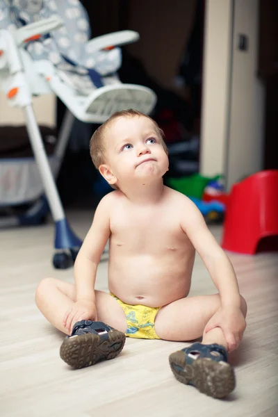 Funny baby boy sitting naked on the floor — Stock Photo, Image