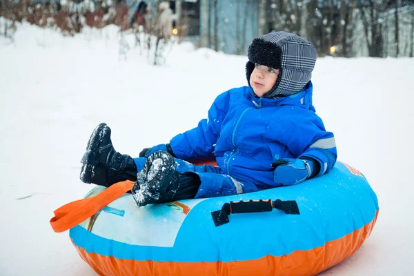 En pojke på en snö-tube — Stockfoto