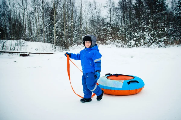 Een jongen op een sneeuw buis — Stockfoto