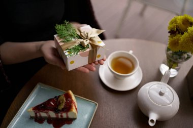 Güzel paketlenmiş bir hediyeyi tutan insan ellerine bir göz atalım.