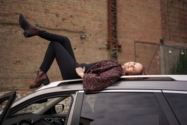 Mulher bonita jazia no telhado do carro — Fotografia de Stock