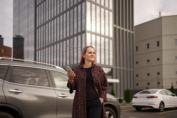 Mulher stand falar uso telefone na cidade perto de carro cinza — Fotografia de Stock