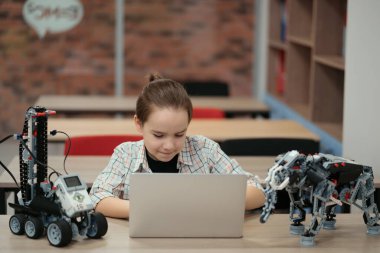 Çocuk tam fonksiyonel robot yapıyor ve bunu okul robotları için dizüstü bilgisayarla programlıyor.