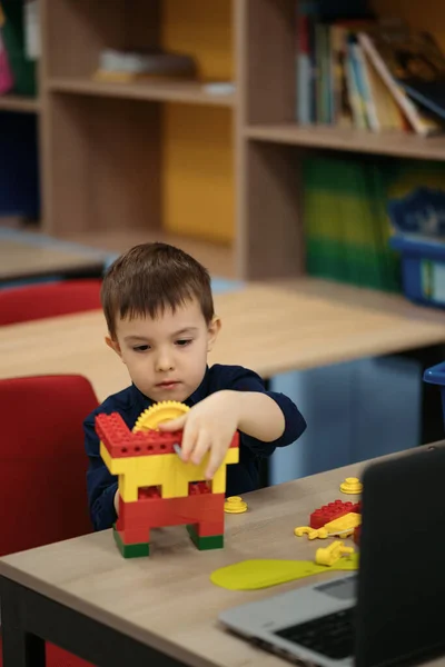 Malý chlapec baví s budováním a tvorbou robota. — Stock fotografie