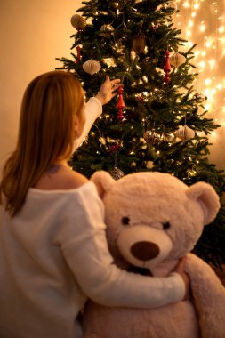 Sarılan kadın Noel ağacına bakıyor