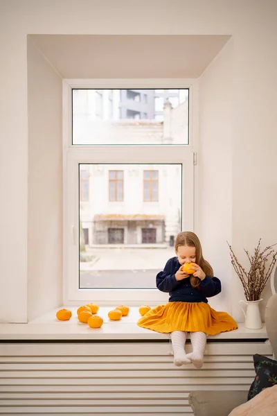 Gadis kecil yang cantik duduk di jendela — Stok Foto