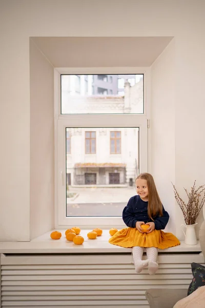 Gadis kecil yang cantik duduk di jendela — Stok Foto
