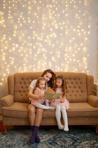 Mutter liest ihren Töchtern zu Hause vor — Stockfoto