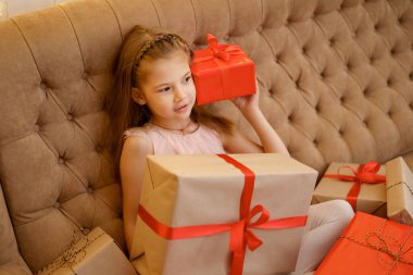Güzel kız hediye kutularını tutuyor ve kutlama anının tadını çıkarıyor.
