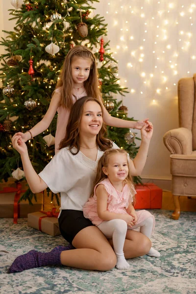 Glückliche Familie mit schönen Kindern am Weihnachtsbaum zu Hause — Stockfoto