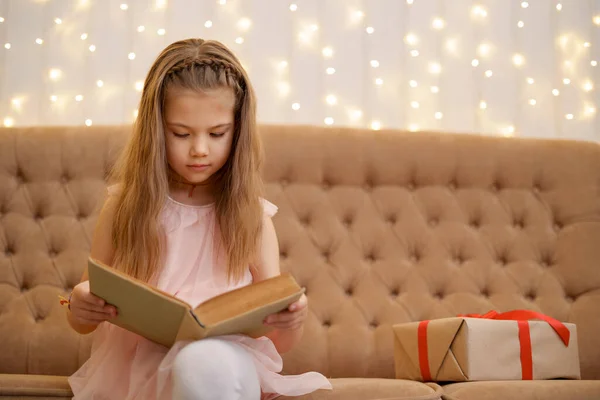 Niña preescolar leyendo un libro en casa — Foto de Stock