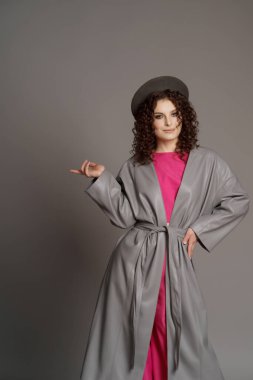 Stüdyo gri arka planda renkli elbiseli bir kadın.