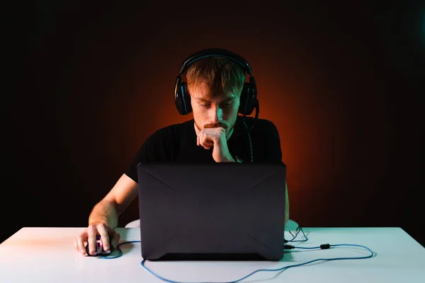 Hráč hraje videohry se sluchátky na neonovém světle pozadí — Stock fotografie
