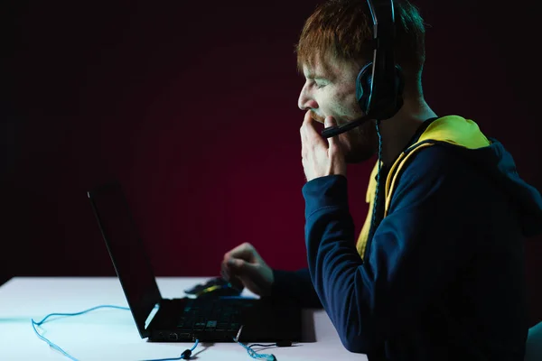Hráč hraje videohry se sluchátky na neonovém světle pozadí — Stock fotografie