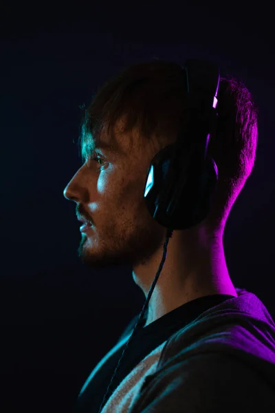 Retrato de homem com fones de ouvido em luzes de néon — Fotografia de Stock