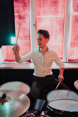 Yakışıklı adam konsere hazırlanırken davul çalıyor.